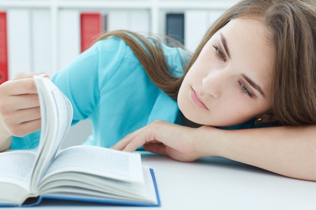 woman looking depressed while trying to read